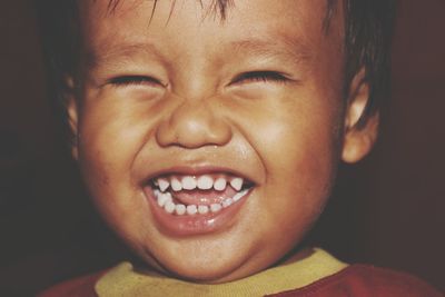 Close-up of smiling boy with eyes closed