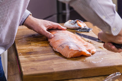 Cropped image of man cutting fish