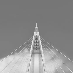Low angle view of suspension bridge cables against sky