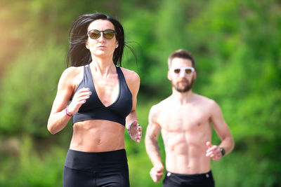 Couple wearing sunglasses running outdoors