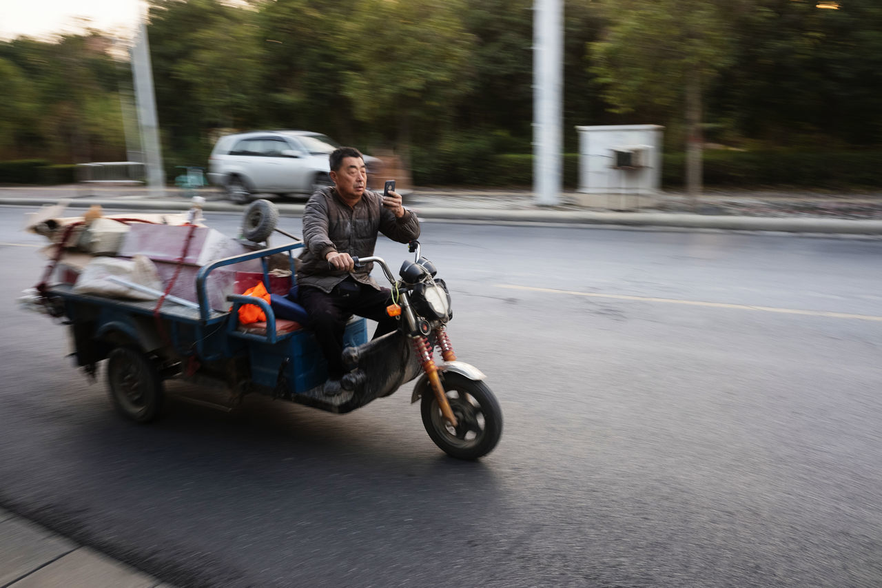 transportation, mode of transportation, land vehicle, road, motorcycle, motion, city, street, speed, blurred motion, travel, real people, one person, driving, day, on the move, ride, riding, journey, outdoors, crash helmet, road trip