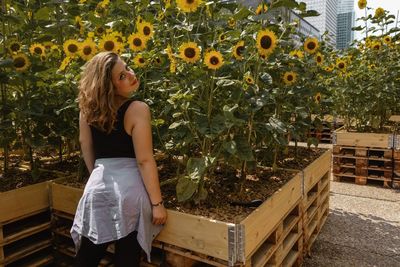 Young woman standing by plants