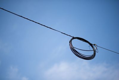 Low angle view of power lines against blue sky