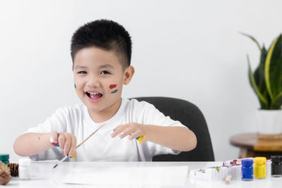 Portrait of cute boy holding table