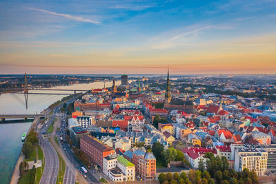 High angle view of townscape by river against sky during sunset