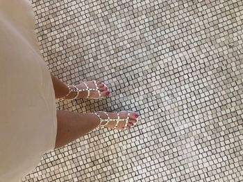 Low section of woman standing on tiled floor
