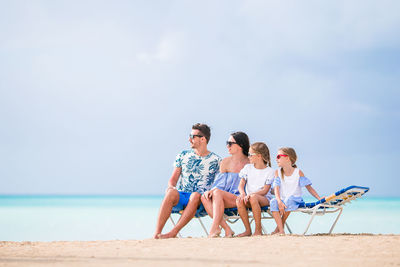 People at beach against sky