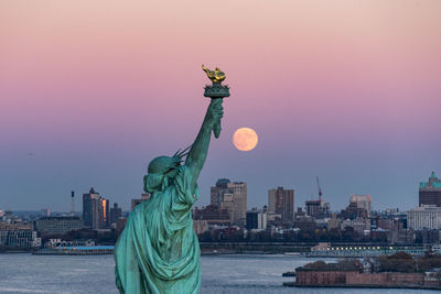 Statue in city at night