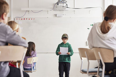 Boy reading in front of class