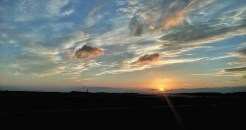 Scenic view of silhouette field against sky during sunset