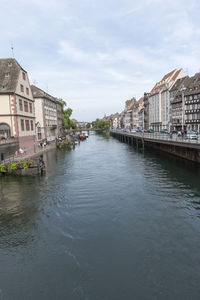 Canal amidst buildings against sky