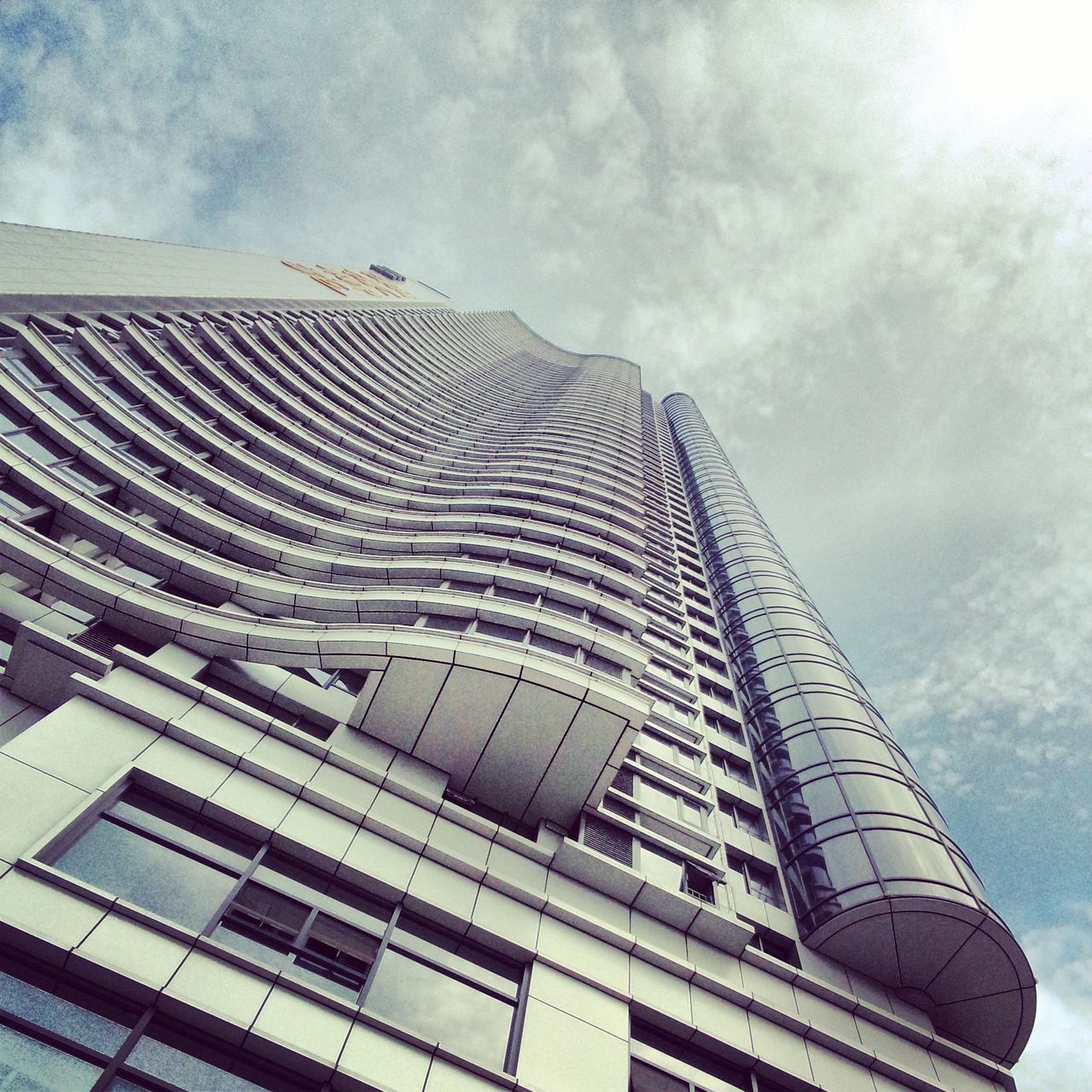 low angle view, architecture, built structure, building exterior, sky, modern, office building, tall - high, city, building, cloud - sky, skyscraper, day, no people, tower, outdoors, glass - material, pattern, architectural feature, cloud