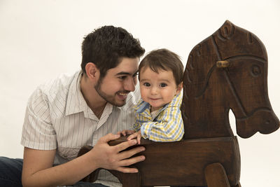 Portrait of father and son against white background