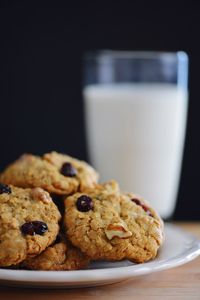 Close-up of cookies by milk in glass on table