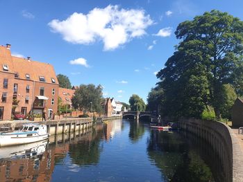 Bridge over canal amidst buildings in city against sky