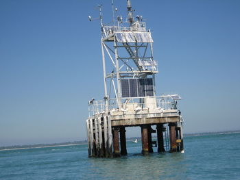 Ship in sea against clear blue sky