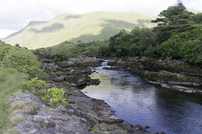 Scenic view of river amidst mountains against sky