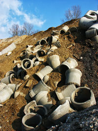 Stack of pipes on field against sky