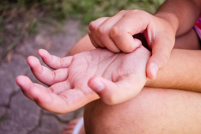 Midsection of boy scratching palm