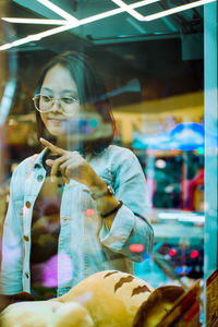 Portrait of young woman in store window
