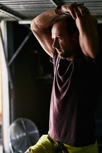 Fit young man stretching in a garage