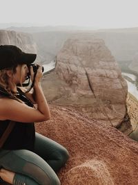 Young woman photographing horseshoe bend through camera