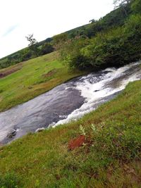 Scenic view of waterfall against sky