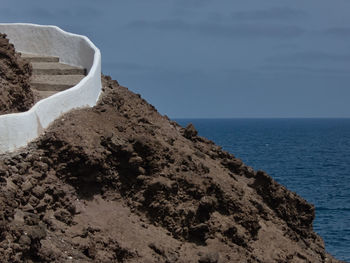 Rock formations in sea against sky