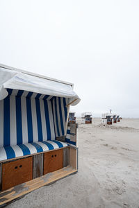 Scenic view of beach against clear sky with beach hut