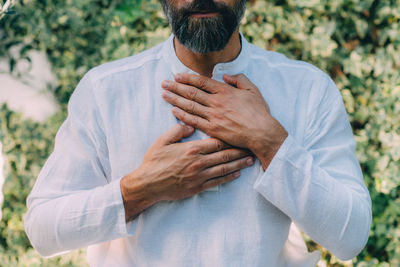 Reiki spiritual self-treatment healing session. man holding hands above the heart chakra.