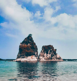 Rock formations in sea against sky