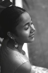 Close-up of smiling young woman with eyes closed