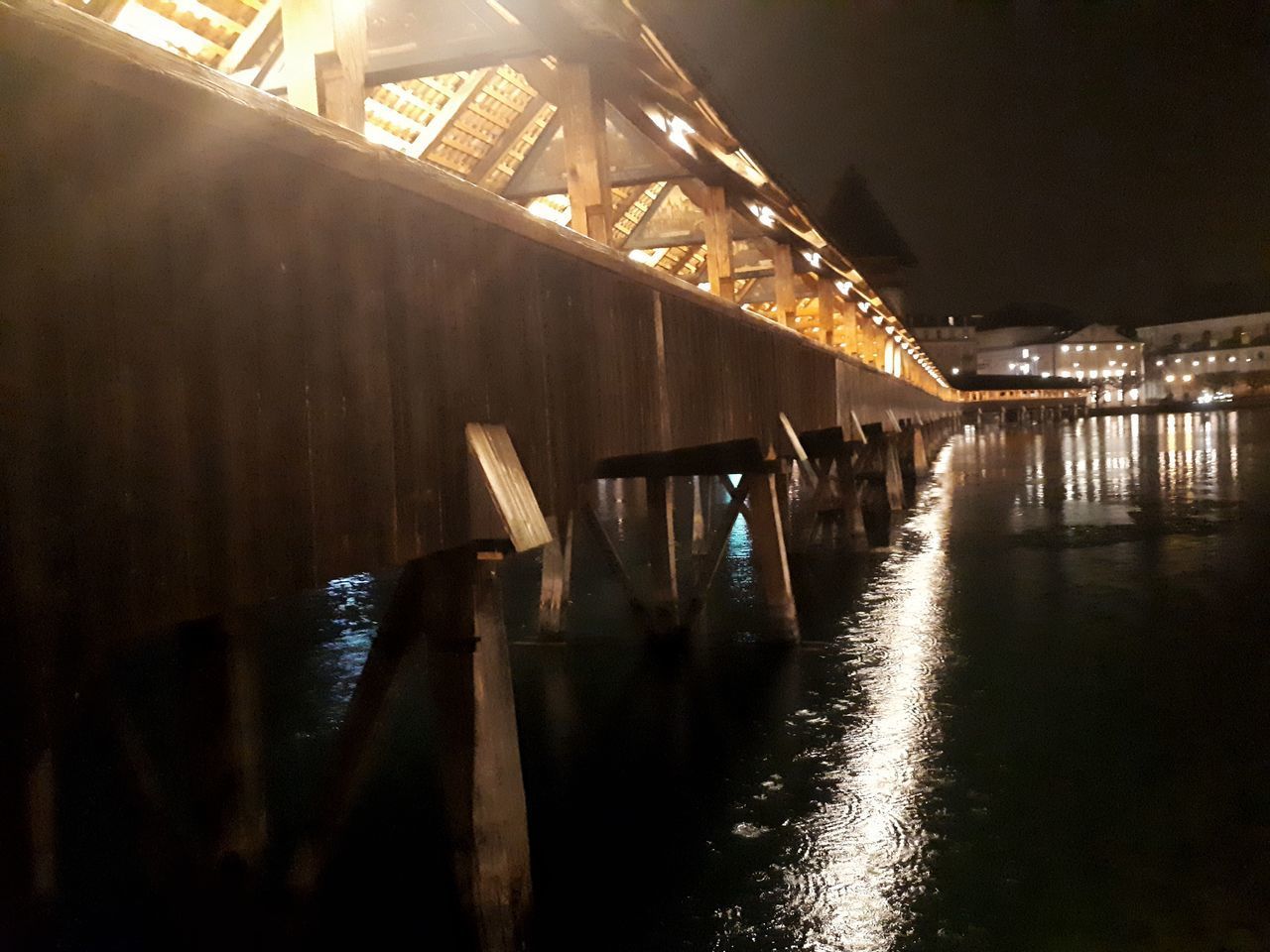 LOW ANGLE VIEW OF ILLUMINATED BRIDGE OVER RIVER