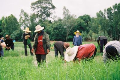 People and dog on farm against sky