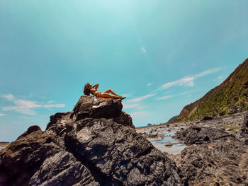 View of bird on rock against sky