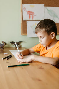 Boy holding paper at home