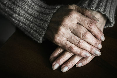 Close up of senior woman hands on table