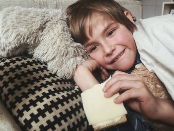 Portrait of cute boy lying on bed at home