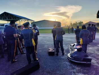 Rear view of people standing on motorcycle against sky