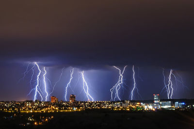 Low angle view of illuminated city against sky at night