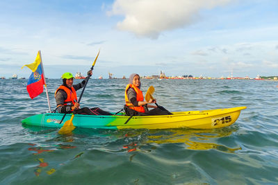 Panoramic view of people on sea against sky