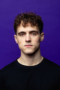 Portrait of young man against blue background