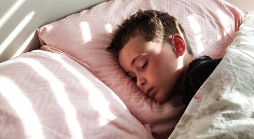 High angle view of boy sleeping on bed at home