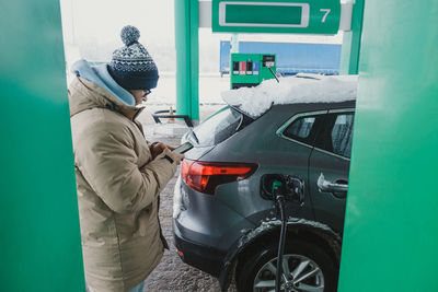 Side view of man holding car