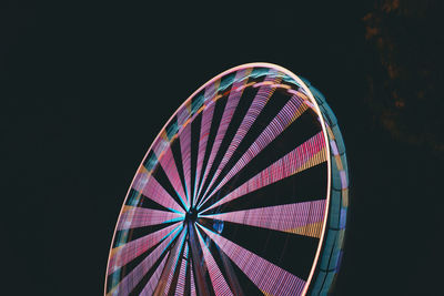 Illuminated ferris wheel against sky at night