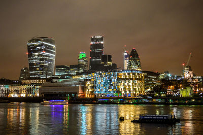 Illuminated cityscape against sky at night