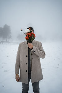 Man with umbrella standing on snow