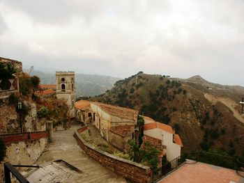 Houses in town against cloudy sky
