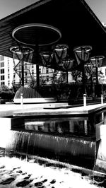 Reflection of bridge in swimming pool against buildings in city