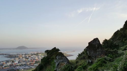 Panoramic view of sea and cityscape against sky